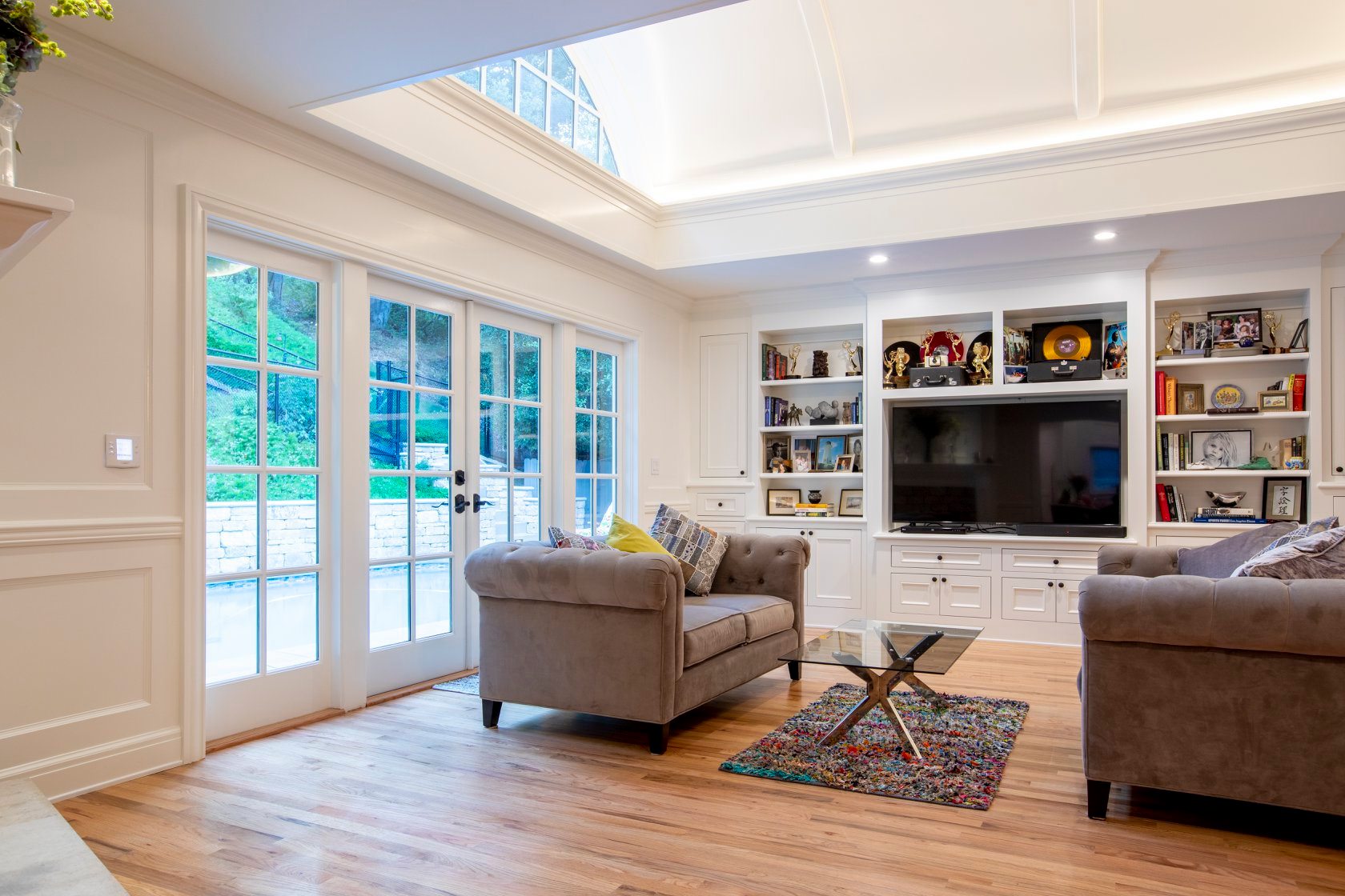 Modern living room with linear fireplace, vaulted ceiling, and forest views