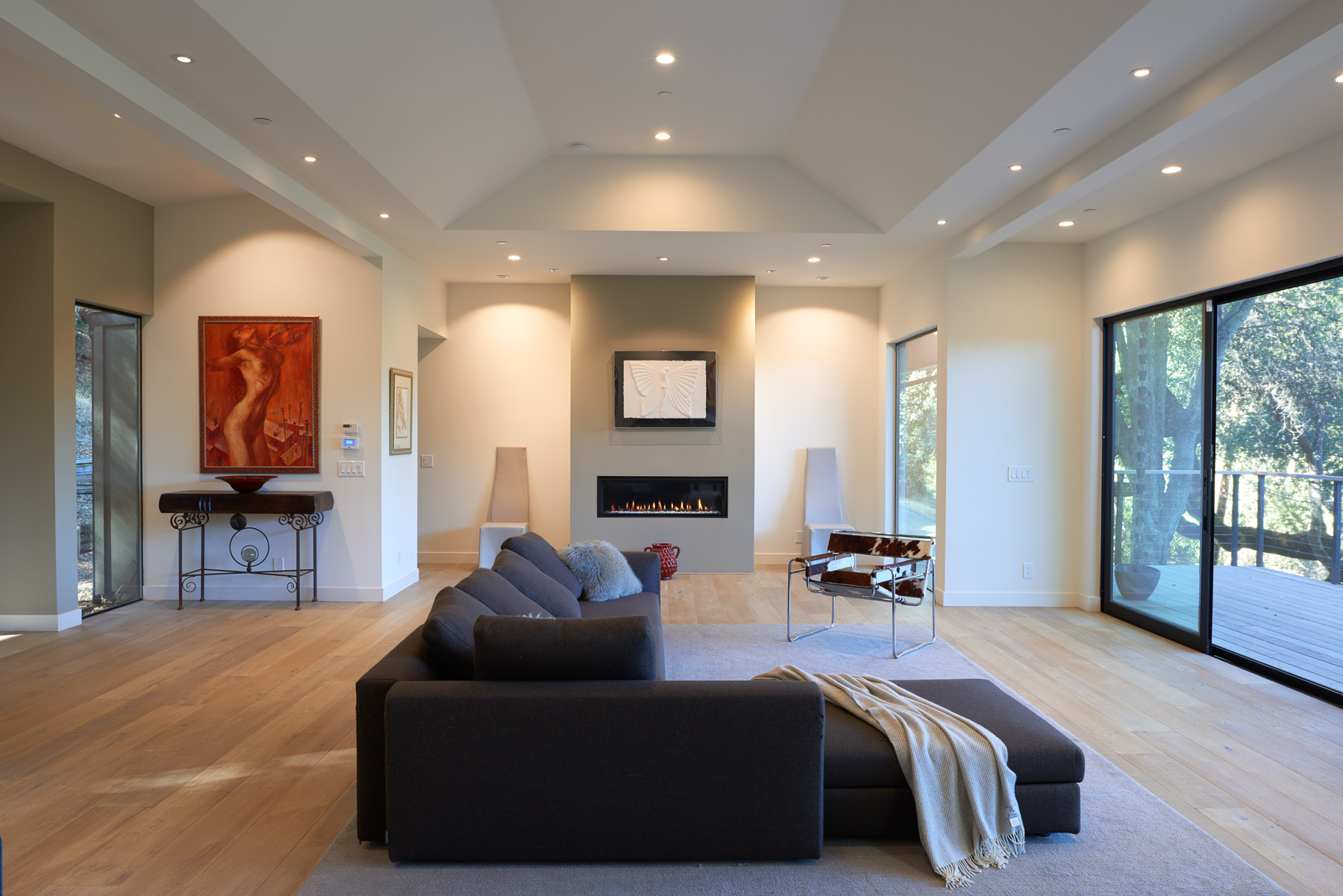 Bright skylit living room with built-in shelving and French doors